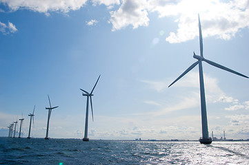 Image showing Windmills in a row on sunny day, close,