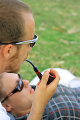 Image showing Boy,  girl and smoking pipe.