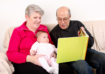 Image showing Family reading book to baby