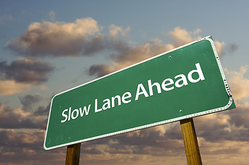 Image showing Slow Lane Ahead Green Road Sign Over Clouds