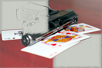 Image showing abstract gun and playing cards on table in casino