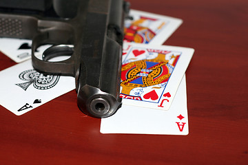 Image showing abstract gun and playing cards on table in casino