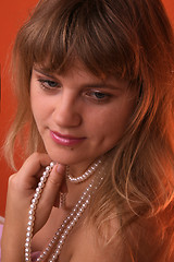 Image showing Sexy young woman with a pearl necklace over red background