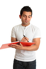 Image showing Man or student writing in a notebook