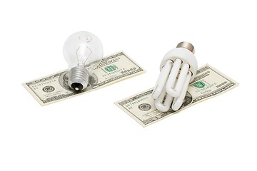 Image showing Energy save lamp versus bulb on dollar bills isolated