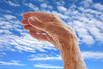 Image showing Senior woman's hand over sky