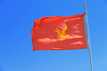 Image showing anchor on red flag blue sky