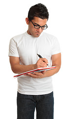 Image showing Man writing in a book notepad