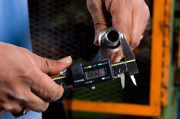 Image showing Hands Holding a Tool Measuring a Pipe
