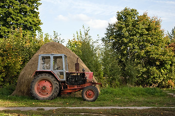 Image showing Old tractor and haystack