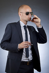 Image showing young businessman drinking and smoking