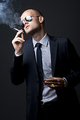 Image showing young businessman drinking and smoking