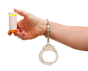 Image showing Handcuffed Man Holding Blank Medicine Bottle Isolated on White