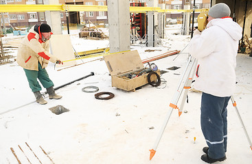 Image showing land surveyor workers using theodolite equipment at construction