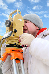 Image showing land surveyor workers using theodolite equipment at construction