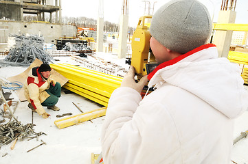 Image showing land surveyor workers using theodolite equipment at construction