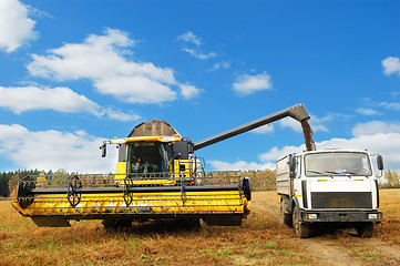 Image showing Combine harvester loading a truck in the field