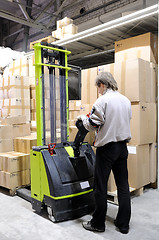 Image showing Operator of electric forklift stacker in warehouse