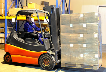 Image showing worker and forklift loader at warehouse