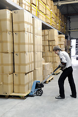 Image showing manual fork pallet truck operator in warehouse