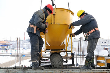 Image showing construction workers pouring concrete in form