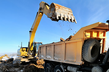 Image showing loader excavator loading earth to body of rear-end tipper