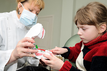 Image showing Medical. Dentist teaching a little girl to clean a teeth