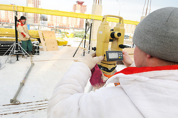 Image showing surveyor worker and theodolite at construction site