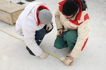Image showing two workers using tape measure