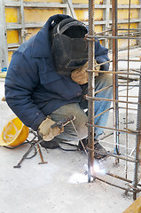 Image showing worker welding a metal lattice at construction site