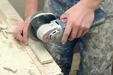 Image showing worker hands cutting a tile