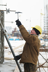 Image showing worker with hammer assembling formwork