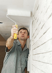 Image showing Painter worker painting a ceiling