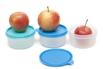 Image showing Three apples and plastic containers