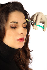 Image showing Young woman receives botox injection in her forehead