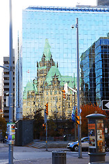 Image showing Old building reflex in glass high rise.