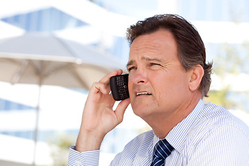 Image showing Businessman Smiles as He Talks on His Cell Phone