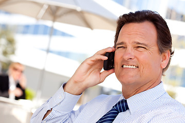 Image showing Businessman Smiles as He Talks on His Cell Phone