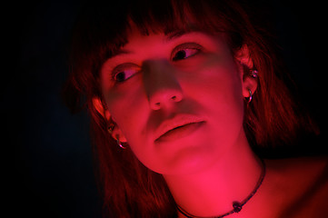 Image showing beautiful woman in dark lit by red