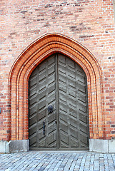 Image showing Old wooden doors in a brick wall