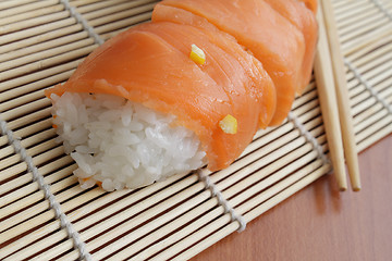 Image showing Salmon sushi on bamboo mat