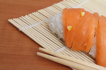 Image showing Salmon sushi on bamboo mat