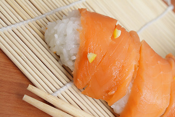 Image showing Salmon sushi on bamboo mat