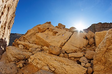 Image showing Sun setting behind the yellow sandstone rock in the desert