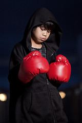 Image showing Young intense asian boy wearing boxing gloves