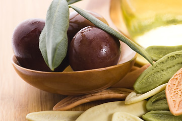 Image showing pasta, black olives, oil with fresh branch. food ingredients 