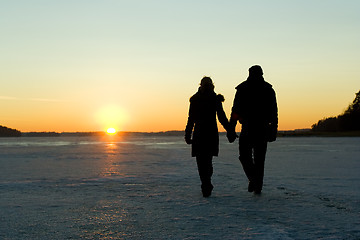 Image showing Couple walking on ice at sunset