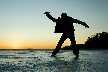 Image showing Silhouette of a man glidin on ice