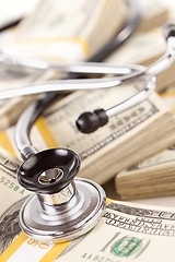 Image showing Stethoscope Laying on Stacks of Money