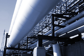 Image showing industrial pipelines on pipe-bridge against blue sky